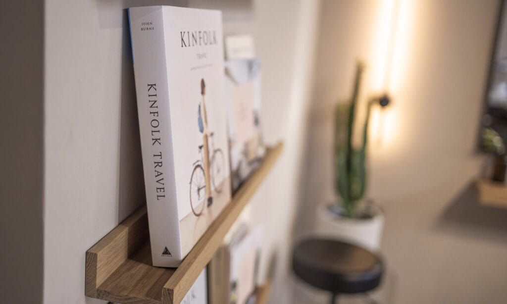 Kinfolk travel book displayed on oak shelf inside mosu hair space